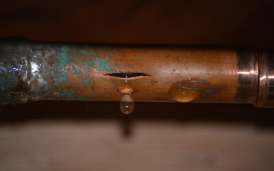 A Ruptured Copper Pipe With Ice On It And Water Dripping From A Crack Caused By The Pipe Freezing.