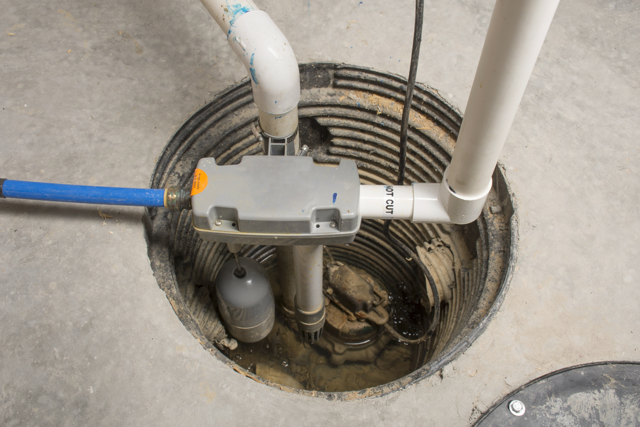 A sump pump pit in a home after new components have been installed to ensure proper functioning.