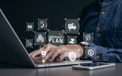 Someone At A Laptop With Emergency Icons Overlaid Above The Keyboard In Representation Of Emergency Planning.